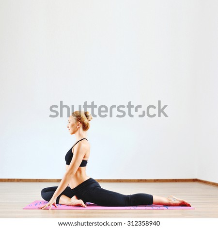 Young woman exercising yoga indoors - copyspace