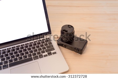 laptop with compact camera  on wood background