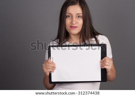 Beautiful young woman holding a billboard sign. Studio shot