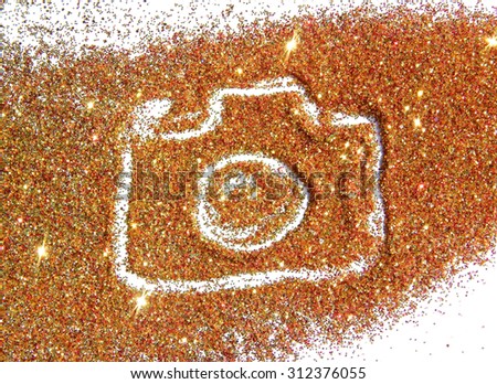 Blurry Photo Camera on golden and red glitter sparkle on white background