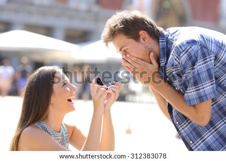 Proposal of a woman asking marry to a man in the middle of a street Royalty-Free Stock Photo #312383078