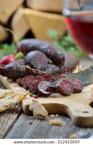 South Tyrolean snack with typical cured sausages (so-called Kaminwurzen) and very crispy flat bread (so-called Schuettelbrot), served with a glass of red wine