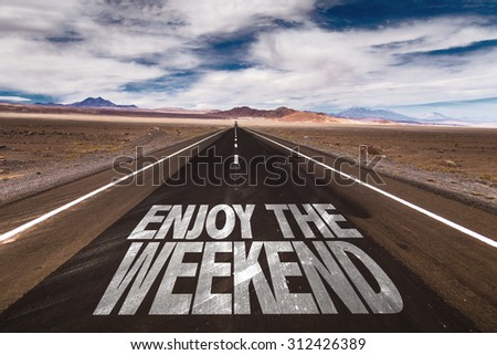 Enjoy the Weekend written on desert road Royalty-Free Stock Photo #312426389