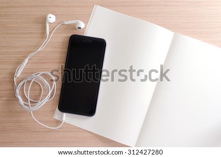 white earphone, smartphone, paper, book, note on wooden background with copy space - vintage effect style picture