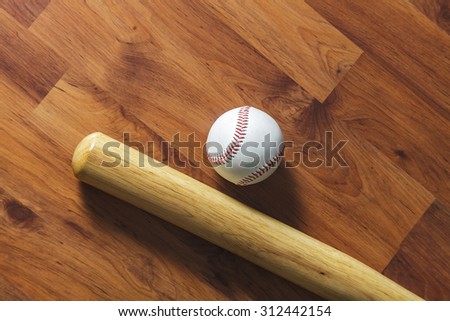 Baseball bat with ball on wood background