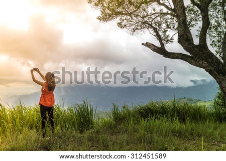 Freedom traveler woman standing take a picture with smartphone and enjoying a beautiful nature at Phu Tab Berk, Phetchabun, Thailand