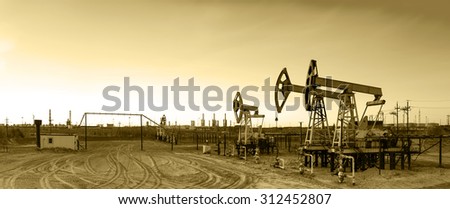 Oil and gas industry. Panoramic of a pump jack and oil refinery. 