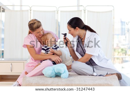 Attractive young doctors attending to a baby