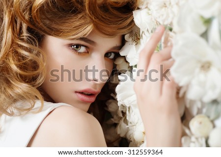 Beautiful young girl on a background of white flowers, the concept of beauty and health