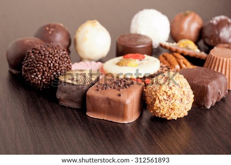 Delicious chocolate candies on wooden background, horizontal