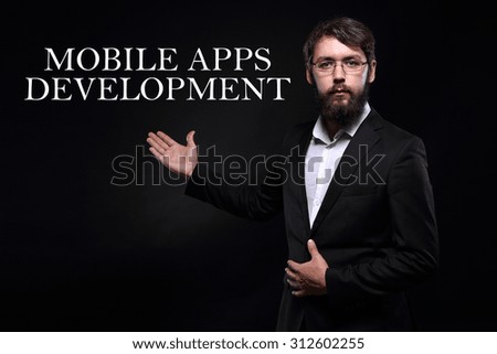 Businessman over black background presenting "Mobile apps development"