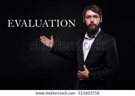 Businessman over black background presenting "Evaluation"