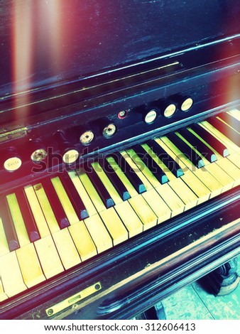 Antique reed organ. Retro style photo with light leaks.