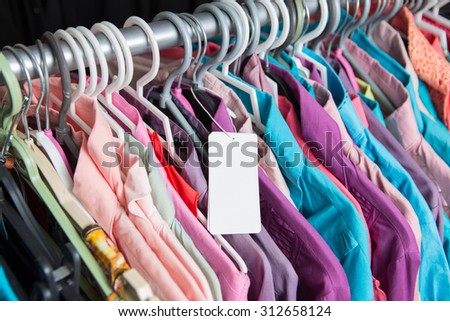 Blank price label on clothes hang on a shelf