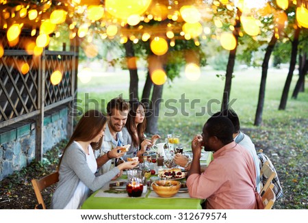 Group of young friends having traditional dinner on Thanksgiving Day