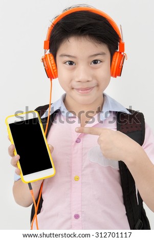 Happy Asian boy ware headphone and Holding cell phone on gray background, smile face