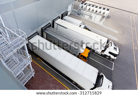 Big distribution warehouse with gates for loads and trucks Royalty-Free Stock Photo #312715829