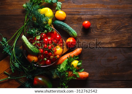 View of a delicious assortment of farm fresh vegetables and herbs  spread out on a rustic wooden table