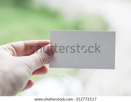 human hand holding white blank business card