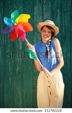Young happy funny (vintage) dressed woman with colorful weather vane,looking like flower Picture ideal for illustrating woman magazines.