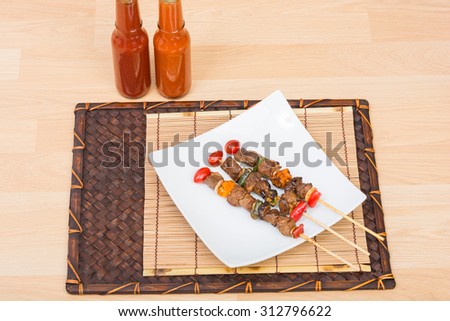 Close up Barbecue in white dish on Wood Table with wooden background.