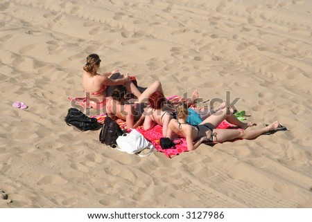 Four young women sunbathing on the beach