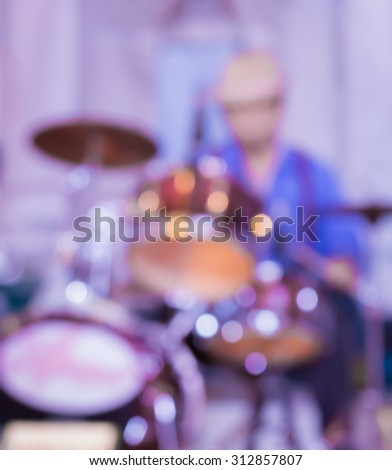 blur musician playing drum in concert hall