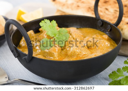 Chicken Korma - Chicken on a mildly spiced creamy sauce served with naan bread and poppadoms. Indian cuisine. Royalty-Free Stock Photo #312862697