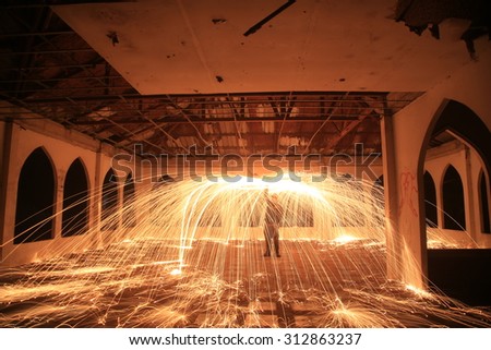 Burning steel wool fireworks in abandoned building.