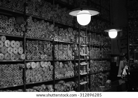 A shelf with vintage wallpaper in small flea market. Image has grain texture - noise seen at 100 percent of its size.