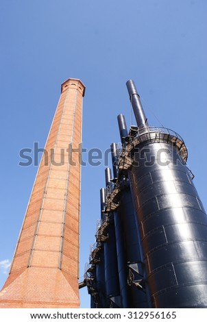 Photograph of an industrial metal structure and a brick tower