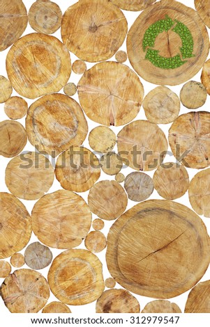 Stacked Logs with green plant recycle symbol, natural wood background