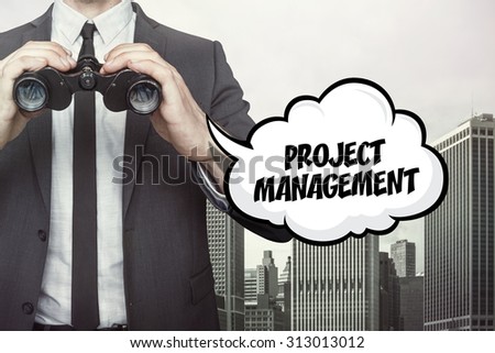 Project management text on speech bubble with businessman holding binoculars on city background