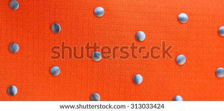 close up of orange fabric texture with silver point