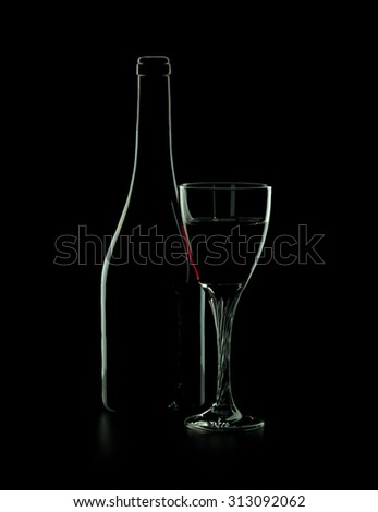 Bottle of red wine with glass on a black background
