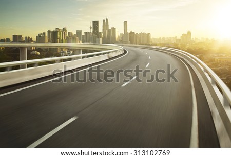Highway overpass motion blur with city background . Royalty-Free Stock Photo #313102769