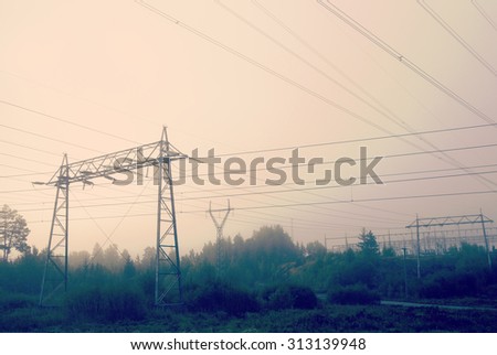 Power lines on a foggy and cold morning. Image has a vintage effect applied and also some grain is added.