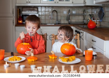 Two adorable boys, preparing jack o lantern for Halloween at home