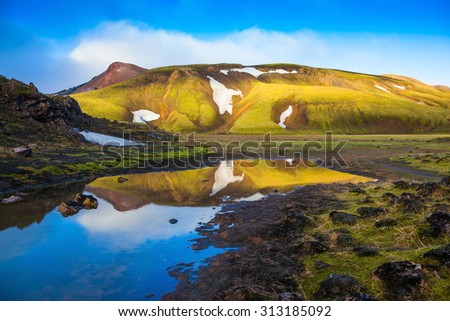 Light golden dawn illuminates the mountains and glaciers national park Landmannalaugar. The  sunrise in Iceland