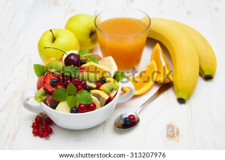 Fruit salad with fresh fruits on a wooden background
