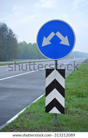 road sign on the highway. the arrows indicate the direction of motion