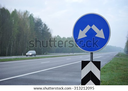 road sign on the highway. the arrows indicate the direction of motion