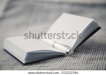 White opened notebook on material background