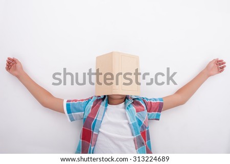 Cute boy is lying on floor and sleeping. He is exhausted of learning. The book is situated on his face. Isolated on background