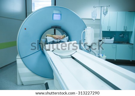 Patient being scanned and diagnosed on a CT (computed tomography) scanner in a hospital. Modern medical equipment, medicine and health care concept.   Royalty-Free Stock Photo #313227290