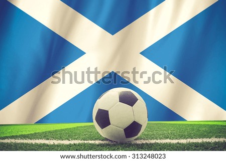 Flag of scotland with football in front of it vintage color