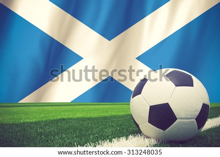 Flag of scotland with football in front of it vintage color