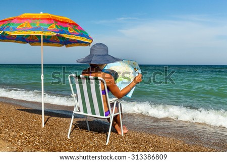 girl on the beach, sunbathing, girl with a laptop, woman under an umbrella, chair, umbrella, plate, rest on the sea, the Black Sea, a sunny day, sign, phone, camera, newspaper, magazine, map, travel
