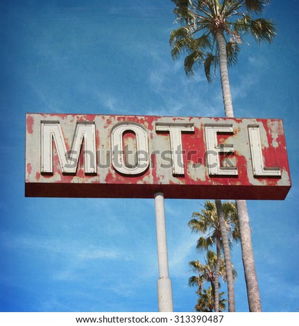 aged and worn vintage photo of neon motel sign with palm trees                             