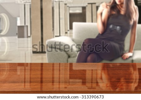 woman in black dress and sofa in room with wooden desk glasses top and sofa 